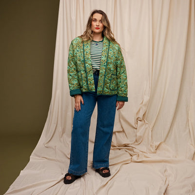Plus size Woman wearing green and white stripe top and dark blue denim pants and Evette Quilted Jacket in Martini