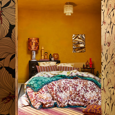 Bed with yellow and brown print pillowcase and Mallorie Velvet Blanket