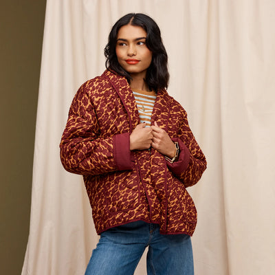 Woman wearing orange and white stripe, denim pants and Odette Quilted Jacket