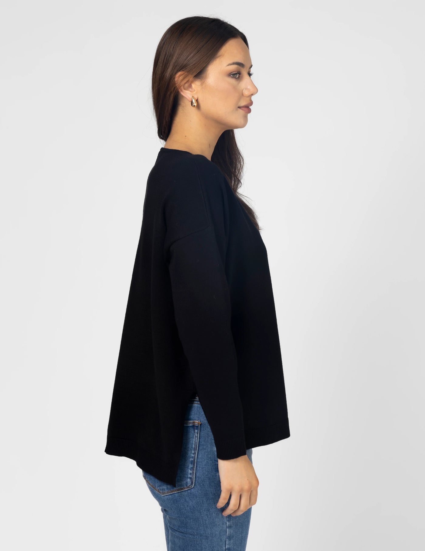 woman facing the side wearing Halle Knit Top - Black and denim pants