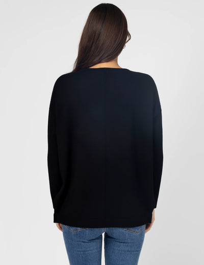 woman facing the back wearing Halle Knit Top - Black and denim pants